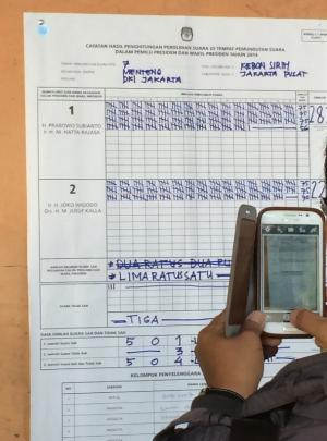 A citizen observer photographs the C1 form in a polling station in Jakarta